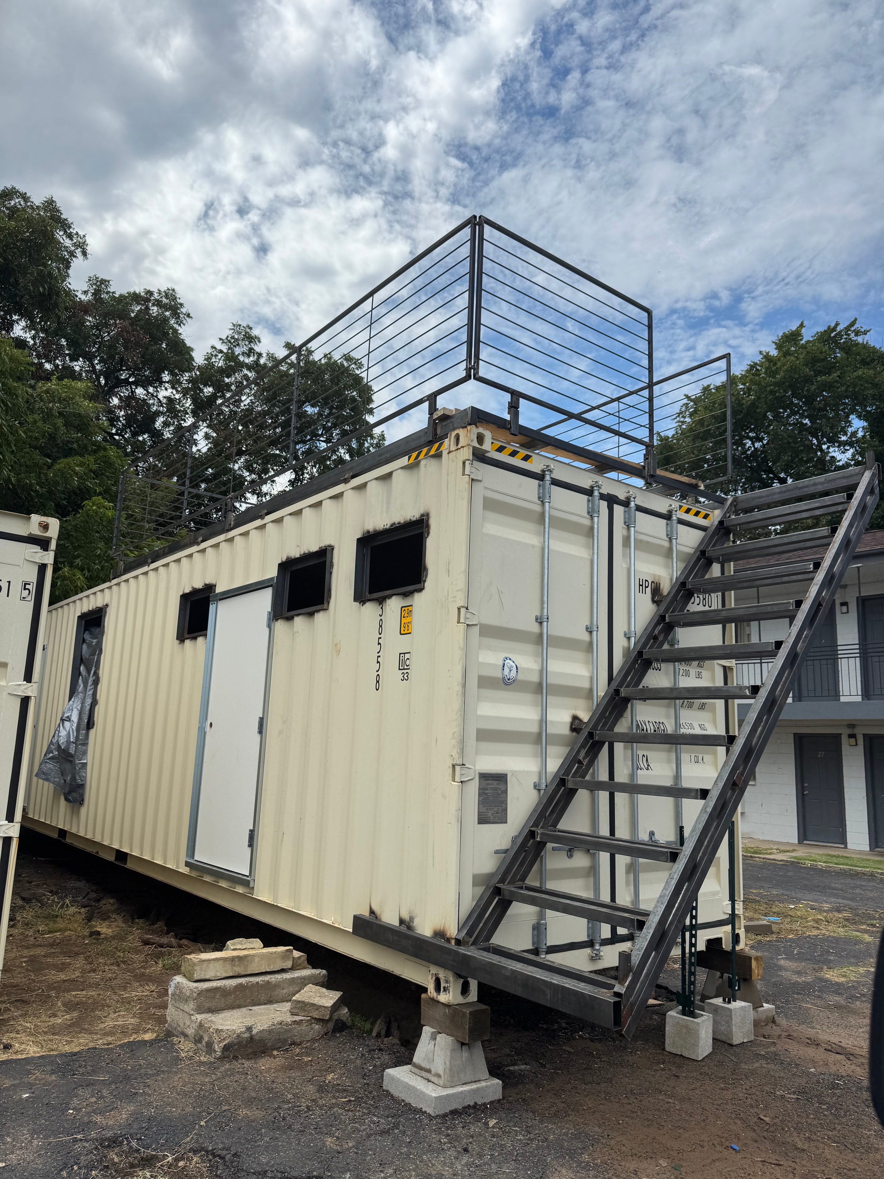 Modified shipping container with rooftop deck